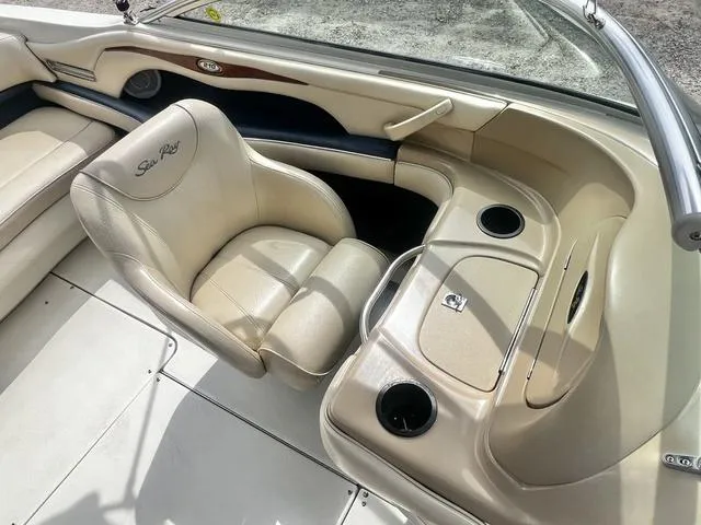 Slide: The Image of 2000 Sea Ray 210 Signature Bowrider interior with beige seating and cup holders. - 19