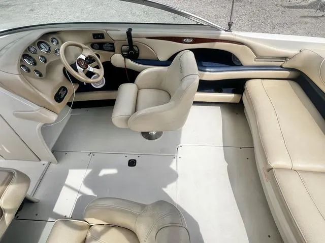 Slide: The Image of 2000 Sea Ray 210 Signature Bowrider interior with beige seating and dashboard controls. - 21