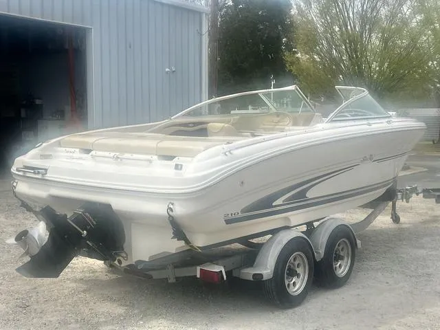 Slide: The Image of 2000 Sea Ray 210 Signature Bowrider on trailer, parked outside a building. - 3