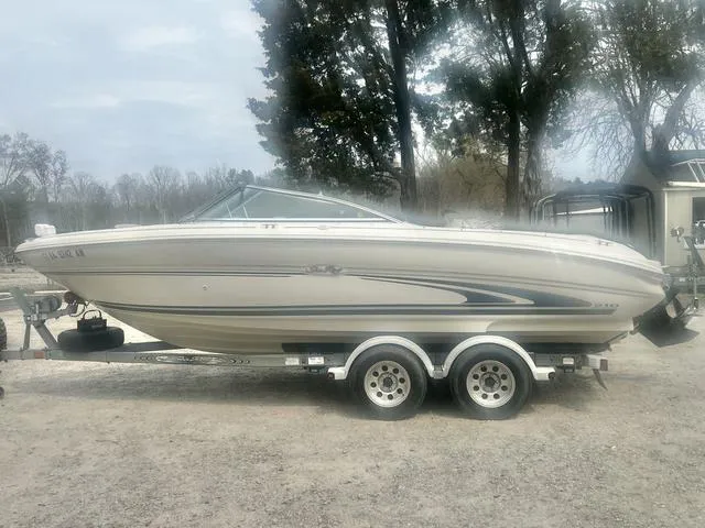 Slide: The Image of 2000 Sea Ray 210 Signature Bowrider on trailer, parked outdoors. - 6