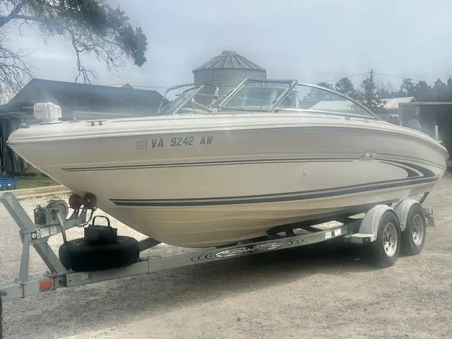 Slide: The Image of 2000 Sea Ray 210 Signature Bowrider on trailer, parked outdoors. - 7