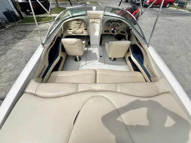 Slide: The Image of 2000 Sea Ray 210 Signature Bowrider interior with beige seating and dashboard view. - 8
