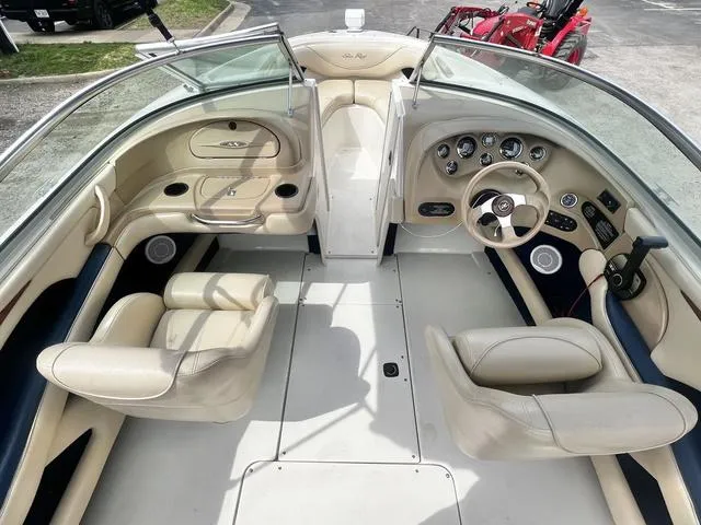 Slide: The Image of 2000 Sea Ray 210 Signature Bowrider interior with beige seating and dashboard controls. - 9