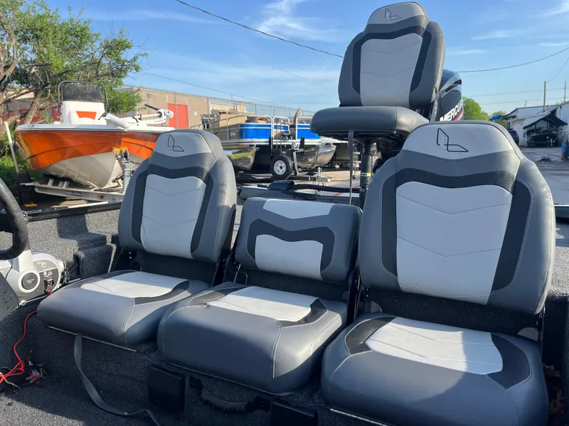 Slide: The Image of 2022 Lowe Legacy boat with MotorGuide, parked outdoors under clear blue sky. - 10