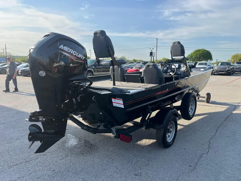 Slide: The Image of 2022 Lowe Legacy boat with gray seating, docked by a lake. - 12