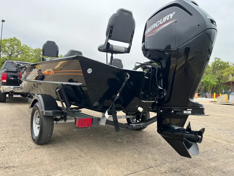 Slide: The Image of 2022 Lowe Legacy boat seats with gray and white upholstery, parked outdoors. - 13