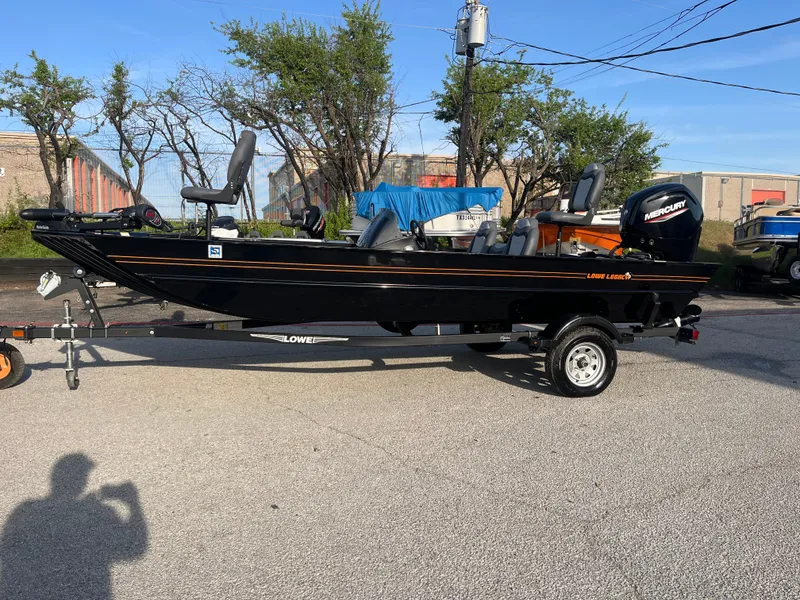 Slide: The Image of 2022 Lowe Legacy boat with Mercury engine on a trailer, parked outdoors. - 21