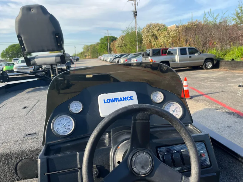 Slide: The Image of 2022 Lowe Legacy boat seat with Mercury engine, outdoor setting, clear blue sky. - 28