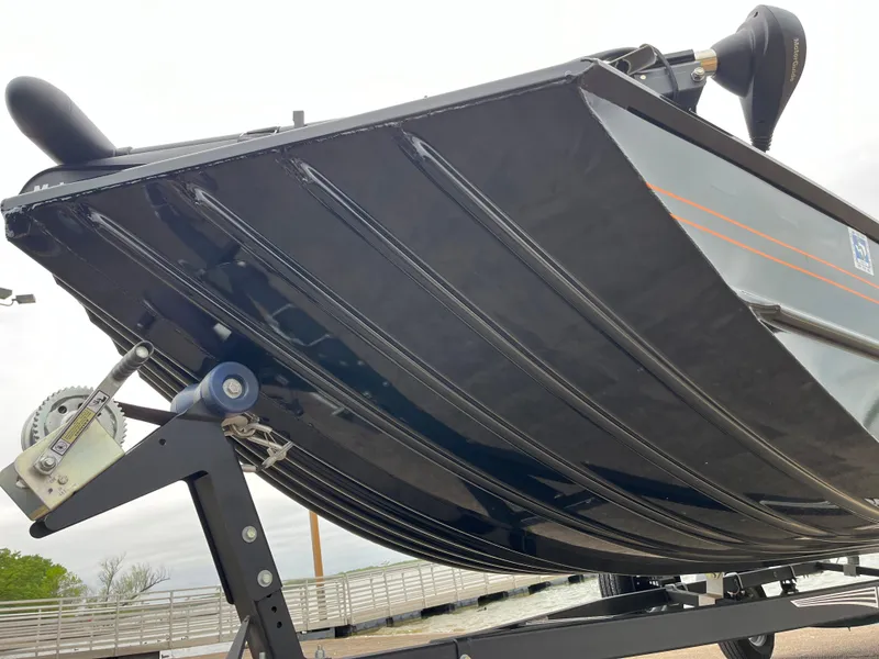 Slide: The Image of 2022 Lowe Legacy boat seats on deck by a lake with cloudy sky. - 36