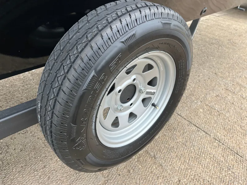 Slide: The Image of 2022 Lowe Legacy trailer tire on a metal rim, parked on concrete. - 43