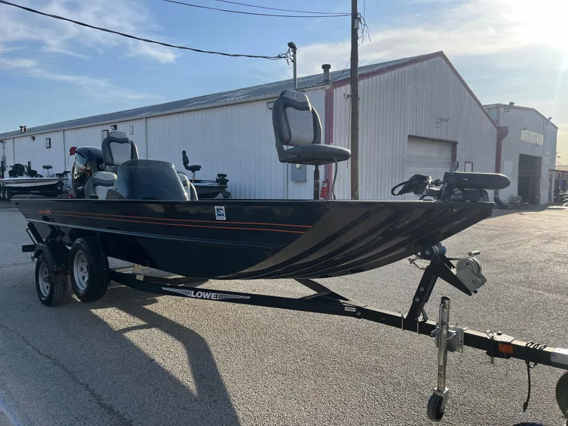 Slide: The Image of 2022 Lowe Legacy boat on trailer, parked outside a warehouse. - 45