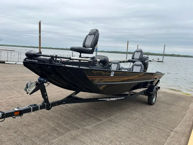 Slide: The Image of 2022 Lowe Legacy boat on trailer by a lake, overcast sky. - 6