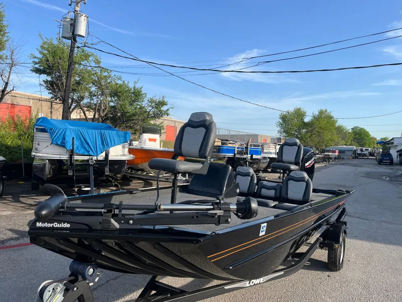 Slide: The Image of 2022 Lowe Legacy boat with Mercury engine on trailer, parked outdoors. - 7