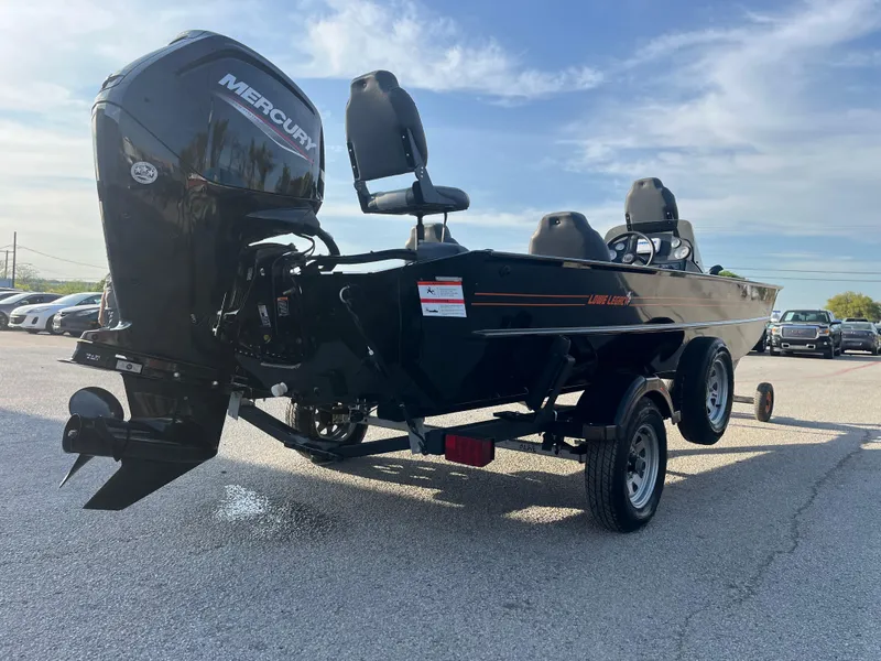 Slide: The Image of 2022 Lowe Legacy boat on trailer by a lakeside dock. - 8