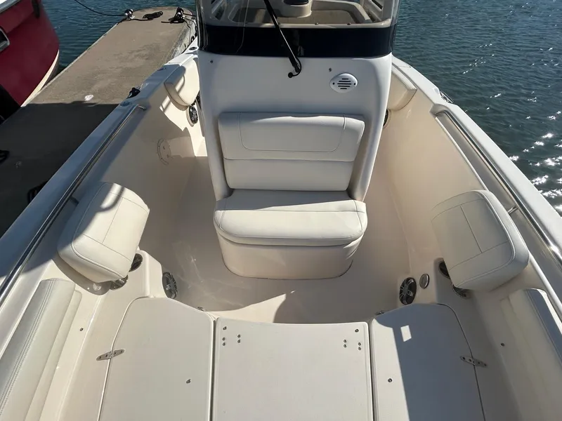 Slide: The Image of 2020 Grady-White Fisherman 257 boat interior with white seating and console, docked by water. - 4