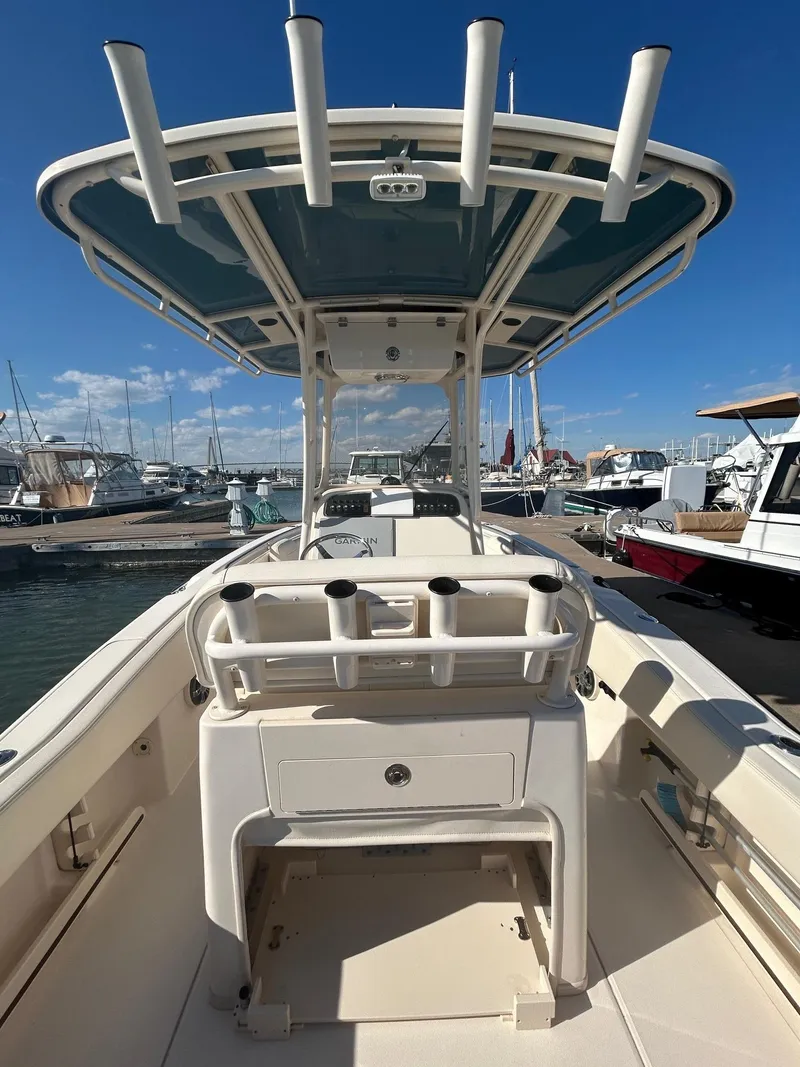 Slide: The Image of 2020 Grady-White Fisherman 257 boat docked at marina, featuring center console and rod holders. - 6