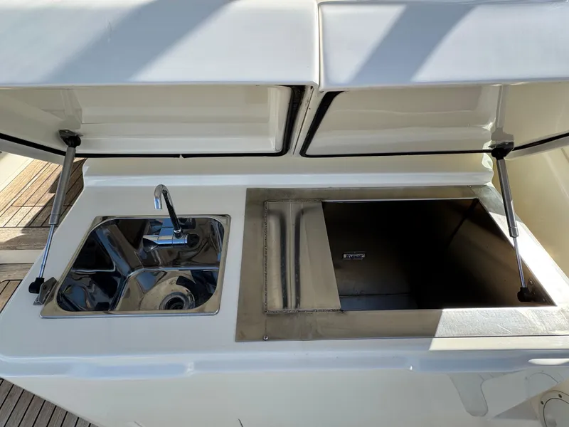 Slide: The Image of 2007 Albemarle 410 Express Fisherman boat sink and storage compartment. - 25