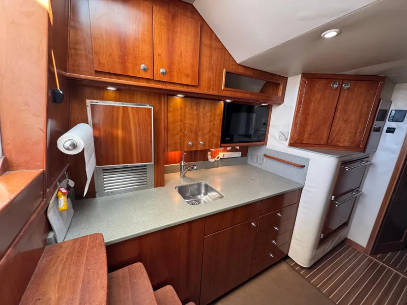 Slide: The Image of 2007 Albemarle 410 Express Fisherman interior with wooden cabinets and modern kitchenette. - 45