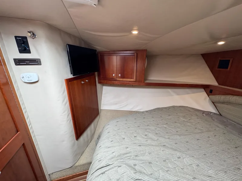 Slide: The Image of 2007 Albemarle 410 Express Fisherman cabin with TV, wooden cabinets, and cozy bedding. - 47