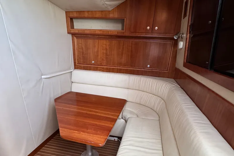 Slide: The Image of 2007 Albemarle 410 Express Fisherman cabin with wooden table and white seating. - 49