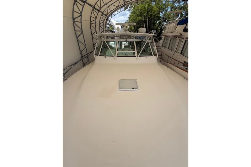 Slide: The Image of 2007 Albemarle 41 Express boat under canopy, showcasing spacious deck and windshield. - 23