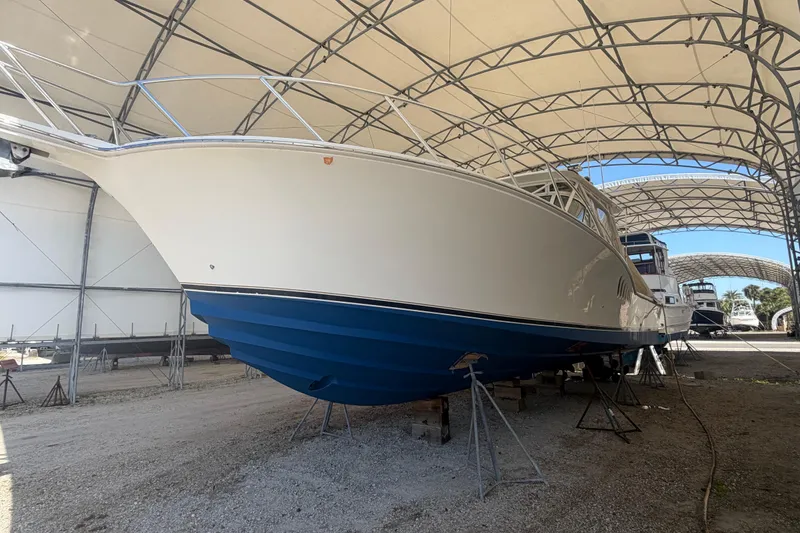 Slide: The Image of 2007 Albemarle 41 Express boat in covered storage, showcasing sleek design and blue hull. - 91