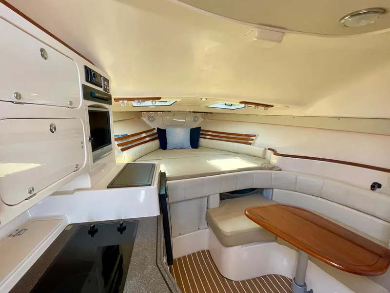Slide: The Image of 2007 Grady-White Express 330 cabin interior with seating, table, and kitchenette. - 10