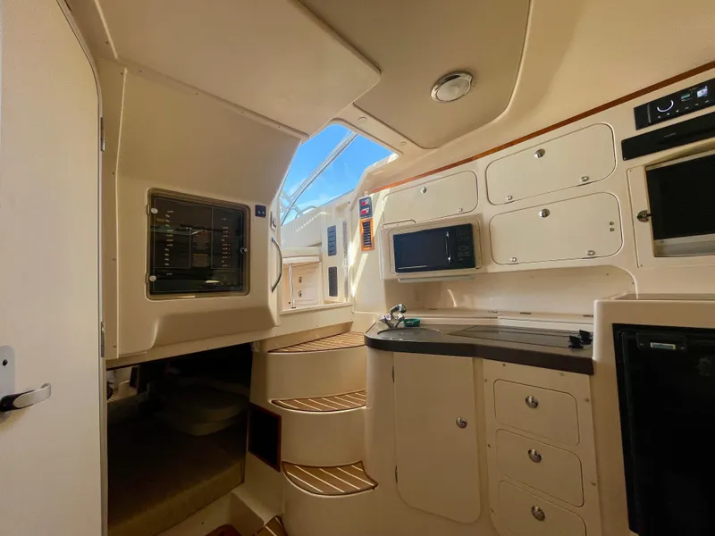 Slide: The Image of 2007 Grady-White Express 330 cabin interior with kitchenette and stairs. - 11