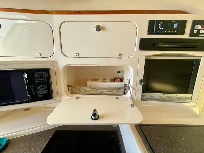 Slide: The Image of 2007 Grady-White Express 330 interior with microwave, storage, and entertainment system. - 14