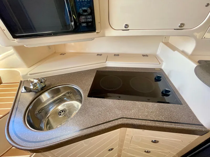 Slide: The Image of 2007 Grady-White Express 330 boat kitchen with sink, stove, and microwave. - 15