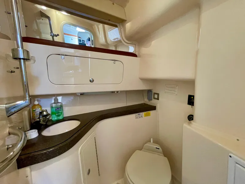 Slide: The Image of 2007 Grady-White Express 330 boat bathroom with sink, toilet, and storage cabinets. - 18