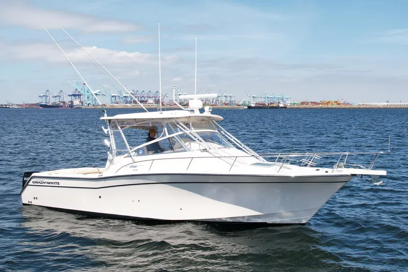 Slide: The Image of 2007 Grady-White Express 330 boat on water with industrial port background. - 2