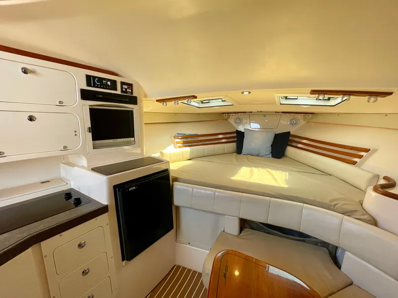 Slide: The Image of 2007 Grady-White Express 330 cabin interior with cozy bed, kitchenette, and storage. - 21