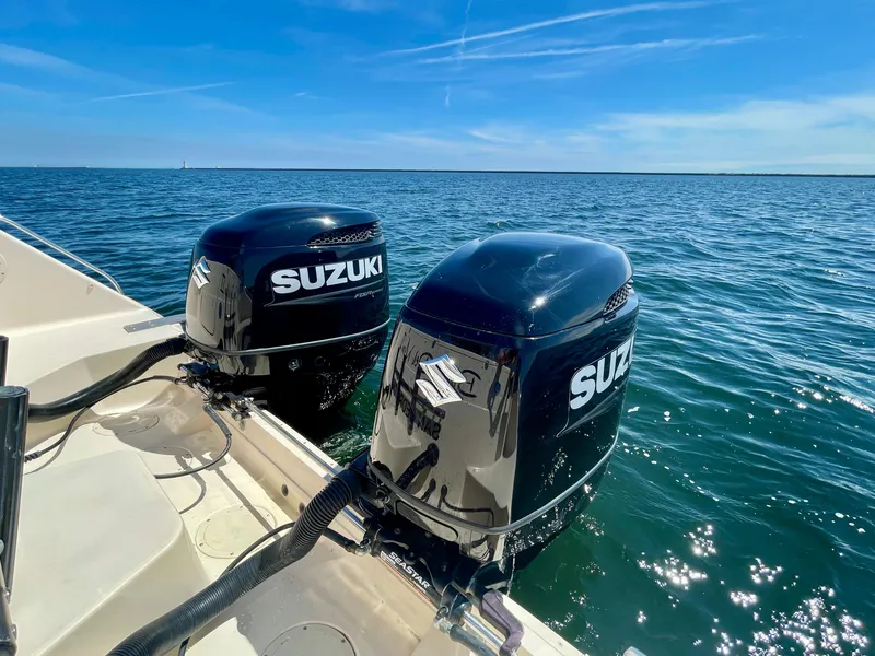 Slide: The Image of Twin Suzuki outboard motors on a 2007 Grady-White Express 330 boat in open water. - 25