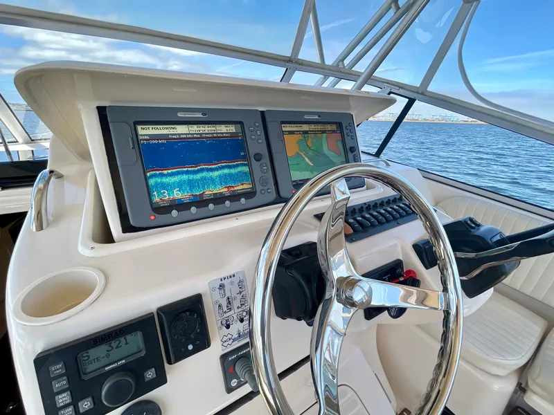 Slide: The Image of 2007 Grady-White Express 330 helm with navigation screens and steering wheel, ocean view. - 37