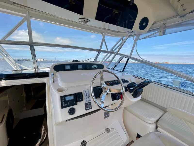 Slide: The Image of 2007 Grady-White Express 330 helm with ocean view, featuring steering wheel and navigation controls. - 41
