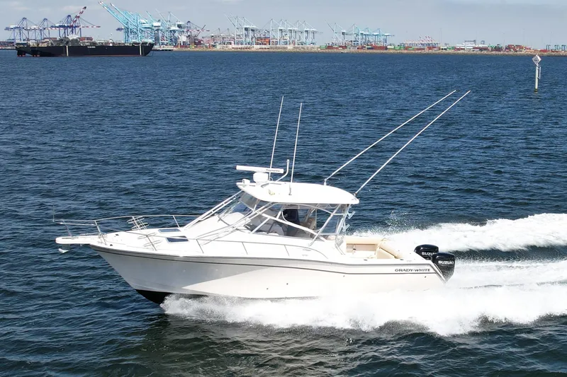 Slide: The Image of 2007 Grady-White Express 330 boat cruising on open water near a port. - 8
