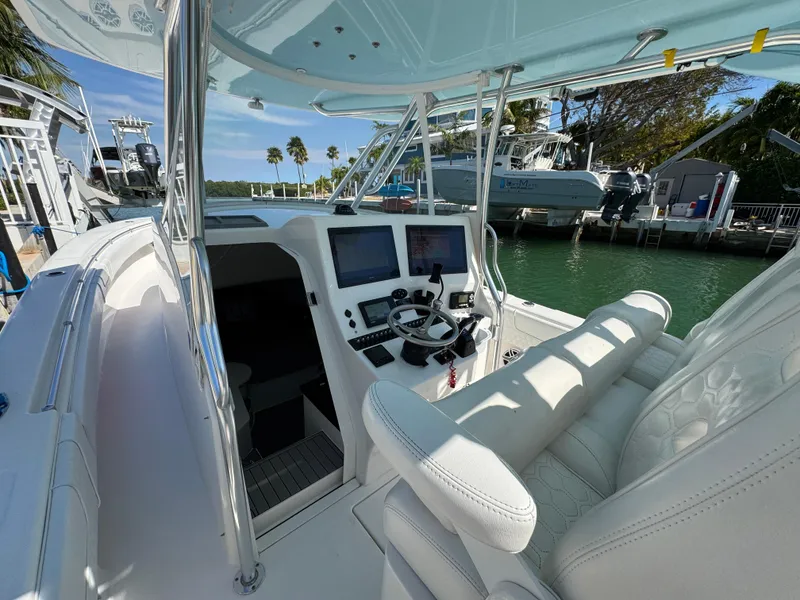 Slide: The Image of 2021 Contender 39 Fisharound boat cockpit with steering wheel and navigation screens. - 11