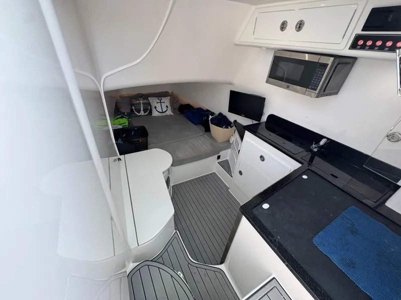 Slide: The Image of 2021 Contender 39 Fisharound cabin with kitchenette, microwave, and seating area. - 12