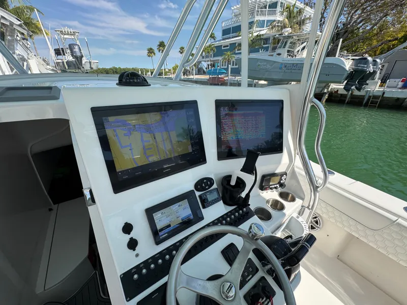 Slide: The Image of Cockpit view of 2021 Contender 39 Fisharound with advanced navigation displays and steering wheel. - 13