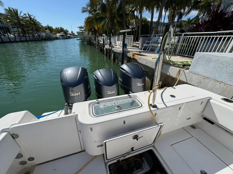 Slide: The Image of 2021 Contender 39 Fisharound with triple 300 horsepower engines docked by a canal. - 22