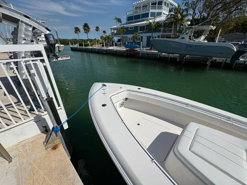 Slide: The Image of 2021 Contender 39 Fisharound boat docked in a marina with palm trees and buildings. - 9