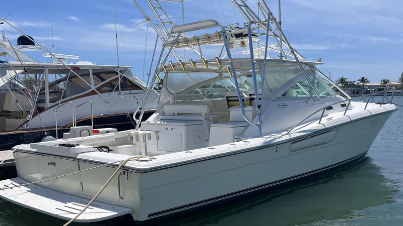 Slide: The Image of 2004 Rampage 38 Express boat docked in marina under clear blue sky. - 1