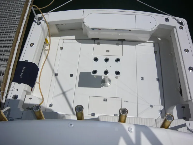 Slide: The Image of 2004 Rampage 38 Express boat deck with fishing rod holders and storage compartments. - 15