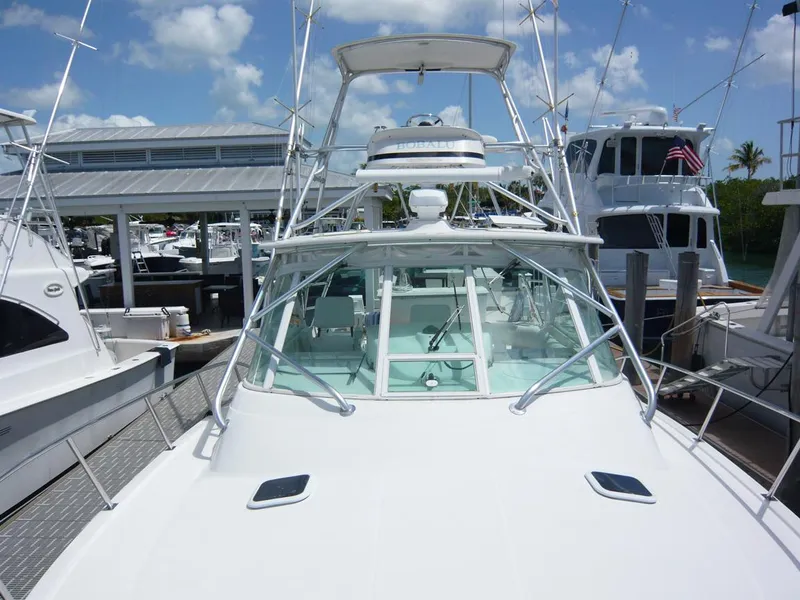 Slide: The Image of 2004 Rampage 38 Express boat docked at marina under clear blue sky. - 19