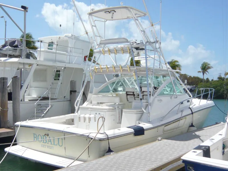 Slide: The Image of 2004 Rampage 38 Express boat docked at marina under clear blue sky. - 2