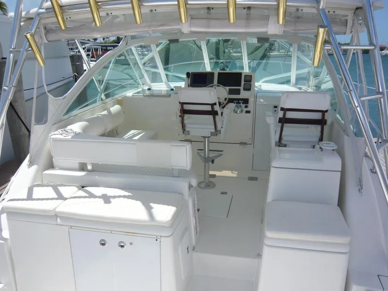 Slide: The Image of 2004 Rampage 38 Express boat interior with helm, seating, and fishing rod holders. - 21