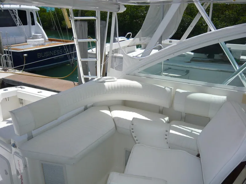 Slide: The Image of 2004 Rampage 38 Express yacht with white seating in a marina setting. - 23