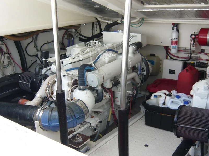 Slide: The Image of Engine room of a 2004 Rampage 38 Express boat, featuring mechanical components and storage items. - 26