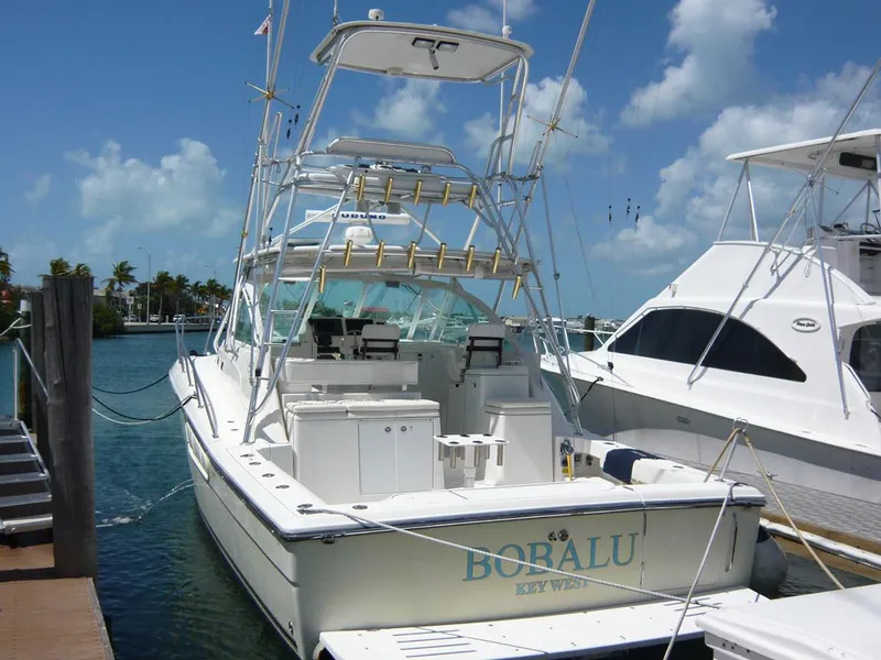 Slide: The Image of 2004 Rampage 38 Express boat docked under a clear blue sky. - 3